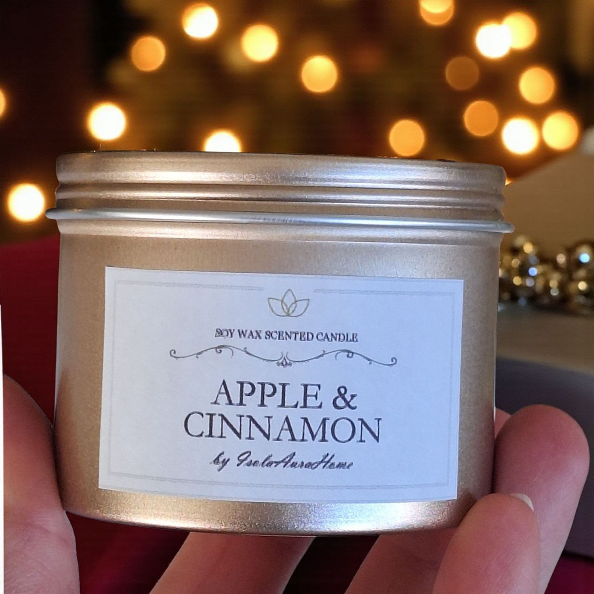 Gold 160 ml Christmas soy candle held in hand to show its size