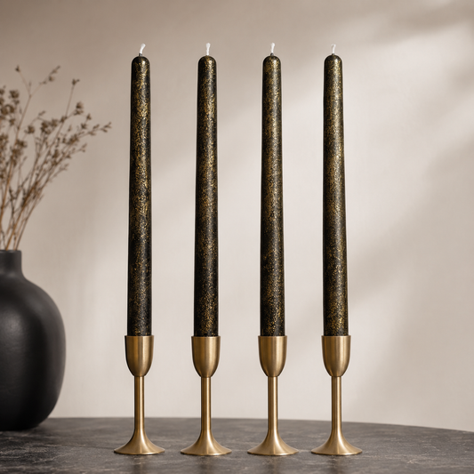 Black and gold soy wax taper candles displayed in gold candle holders, handmade in Belgium