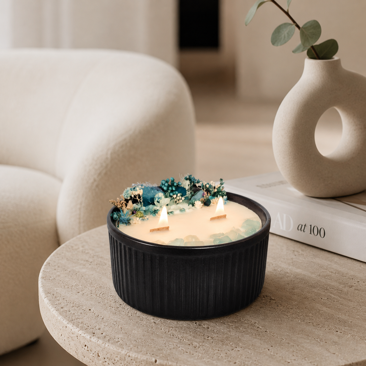 Lit Blue Bloom and Aquamarine floral crystal candle styled in a calm neutral home interior