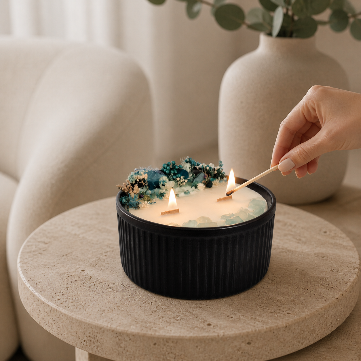 Lighting the wooden wicks of a Blue Bloom and Aquamarine floral crystal candle