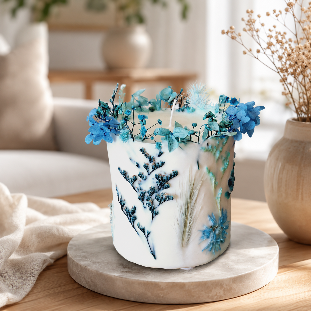 Blue botanical soy wax candle with dried flowers styled in a soft home interior