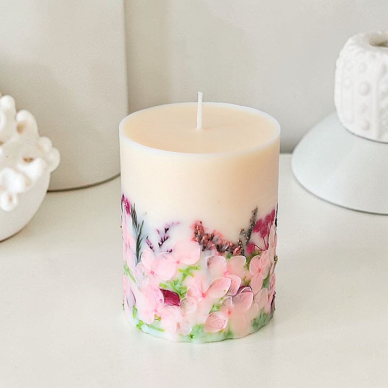 Handmade blush floral soy wax candle with dried flowers in soft pink and green tones