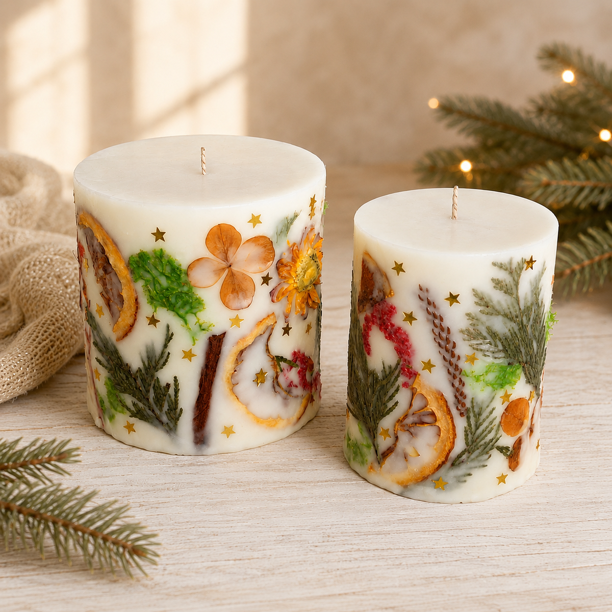 Large and small handmade botanical Christmas candles with natural dried decorations displayed side by side.
