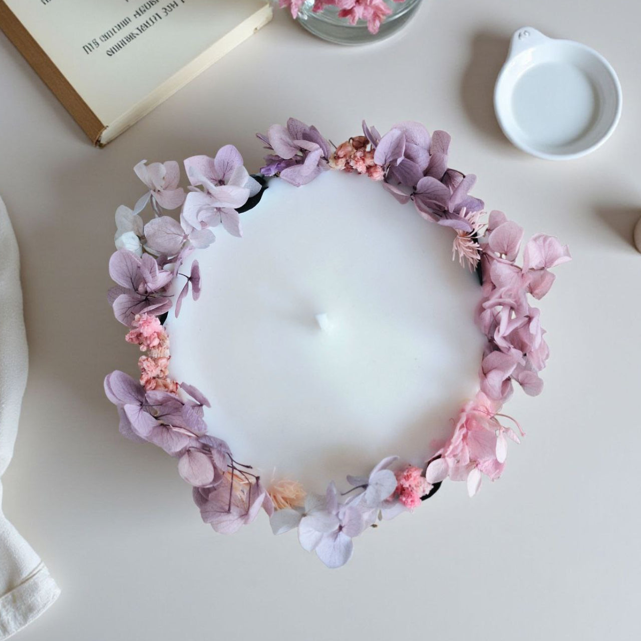 Top view of botanical soy wax candle decorated with pink and purple dried flowers
