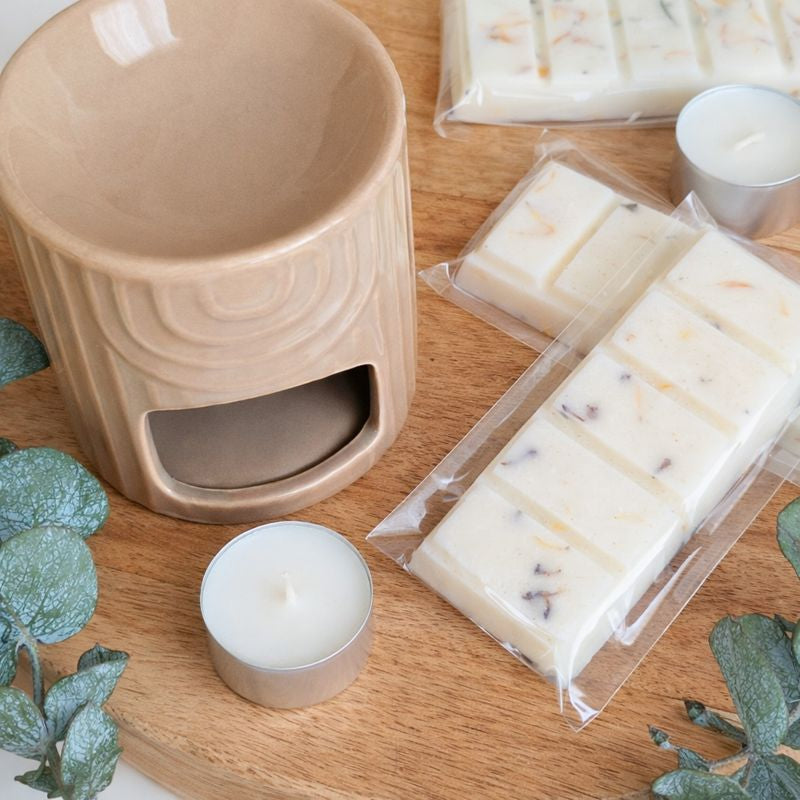Close-up of ceramic wax melt burner with soy wax melts and mini candles for home fragrance
