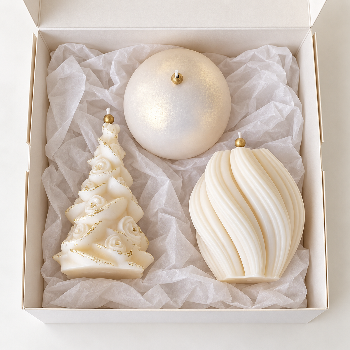 Open white gift box with floral Christmas tree, spiral and pearlescent sphere candles arranged in tissue paper