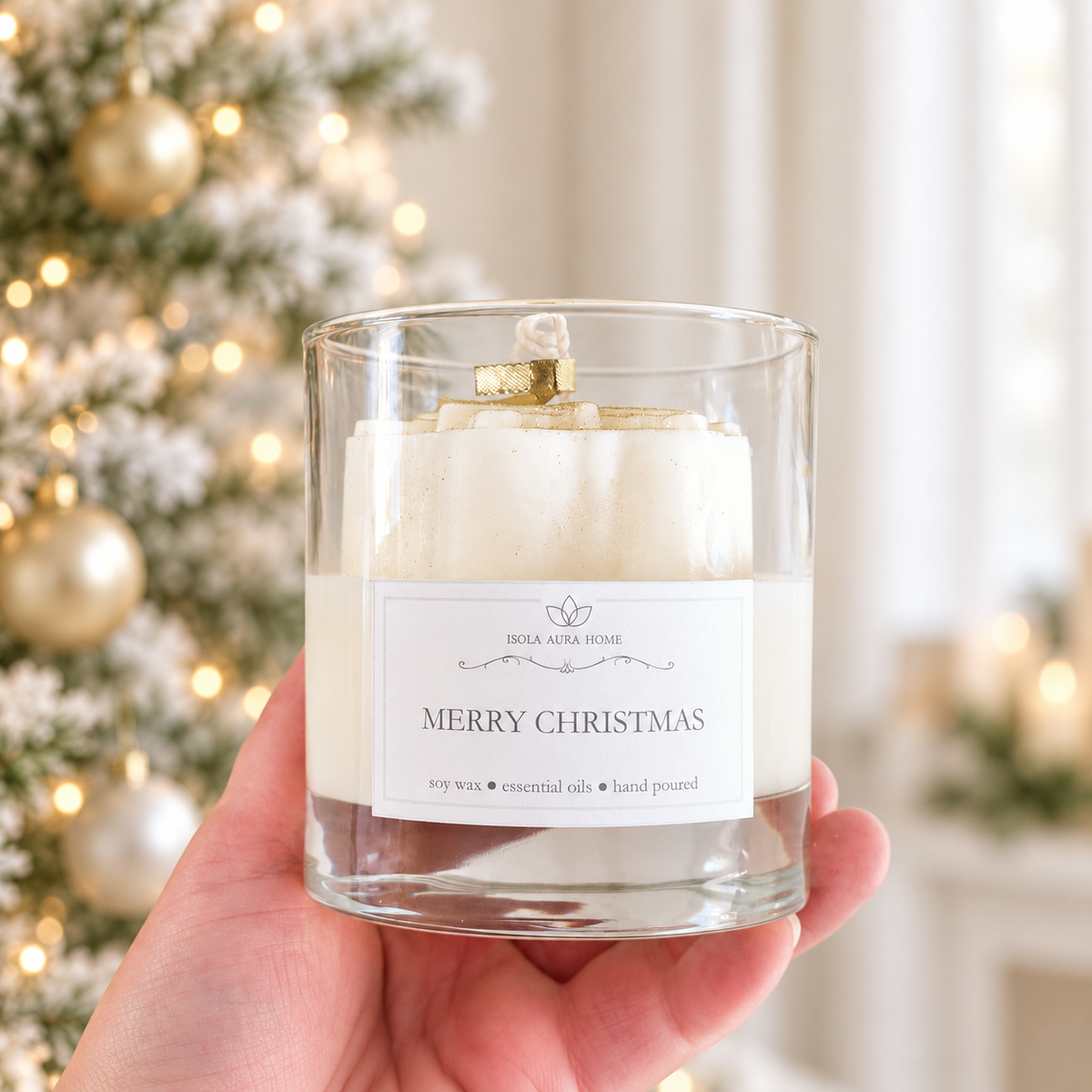 Merry Christmas soy candle held in hand to show the size and decorative snowflake detail