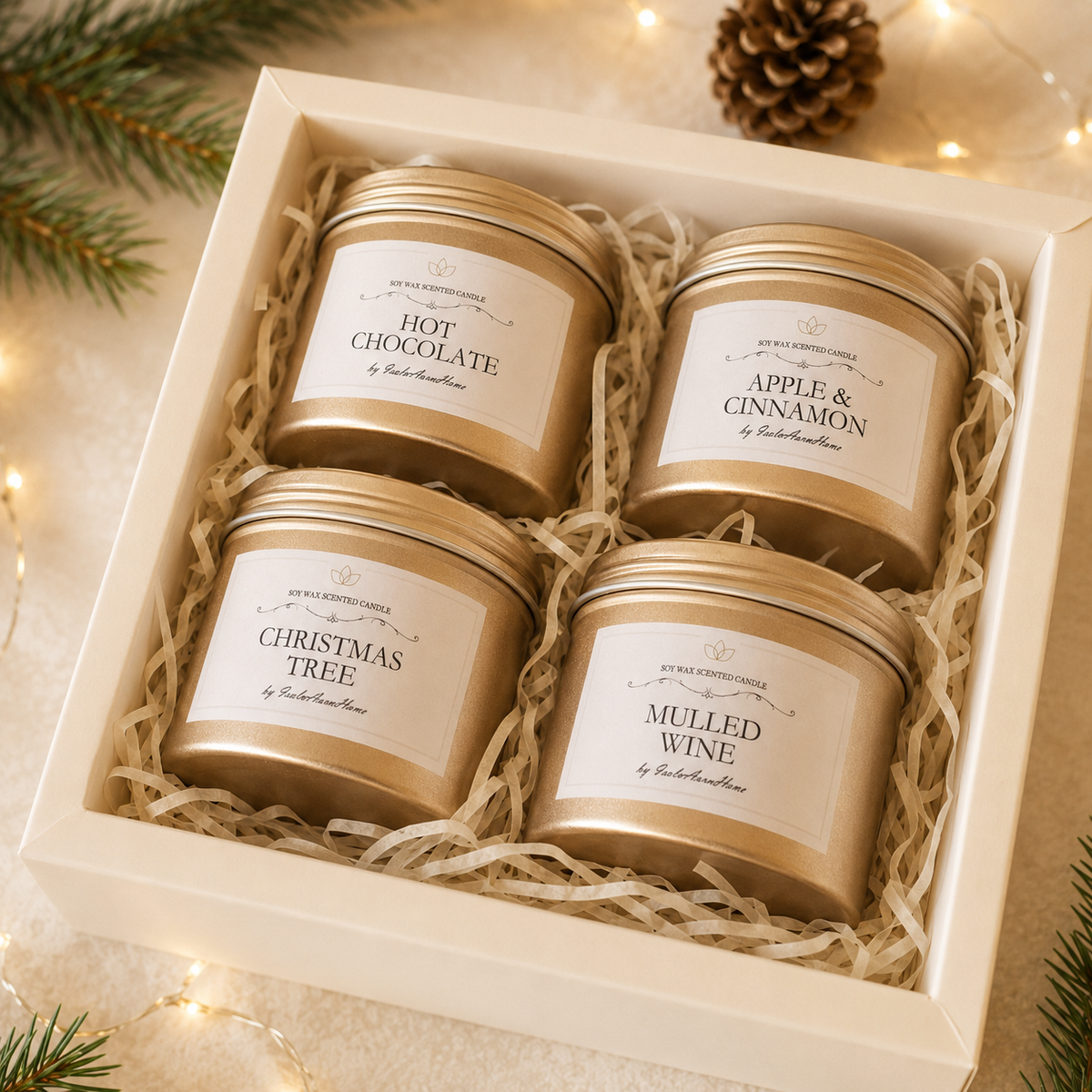 Four gold tin Christmas candles arranged in an elegant ivory gift box
