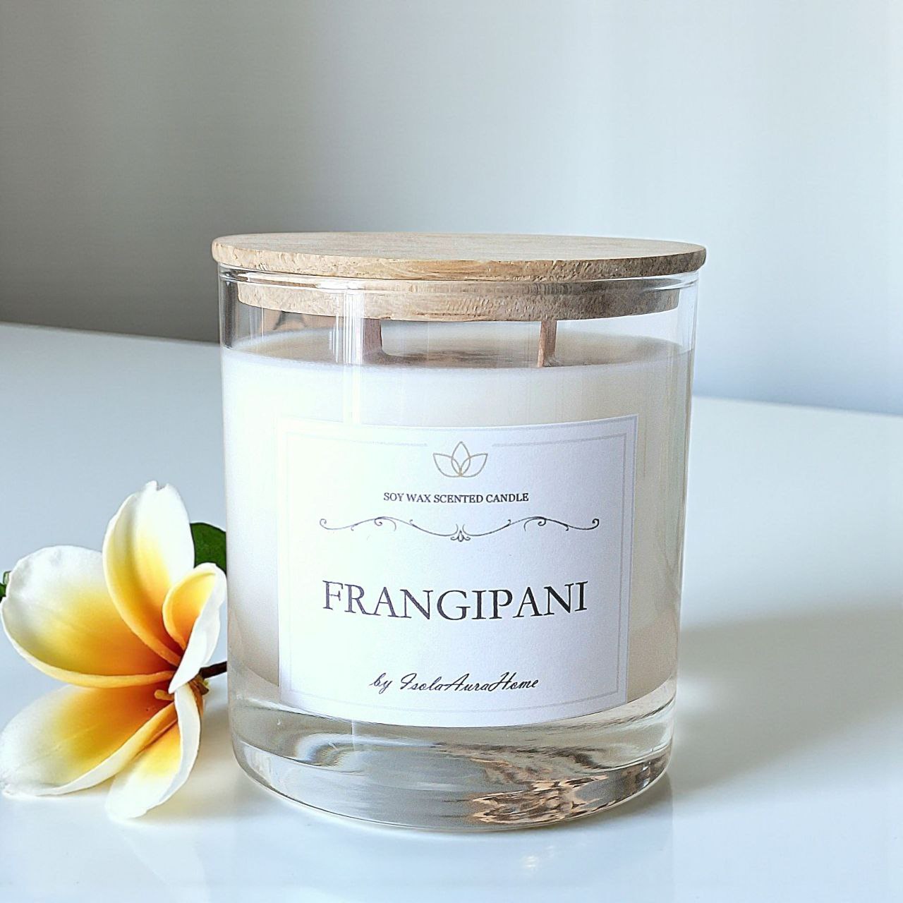 Frangipani soy wax candle in a glass jar with wooden lid, handmade by Isola Aura Home in Belgium