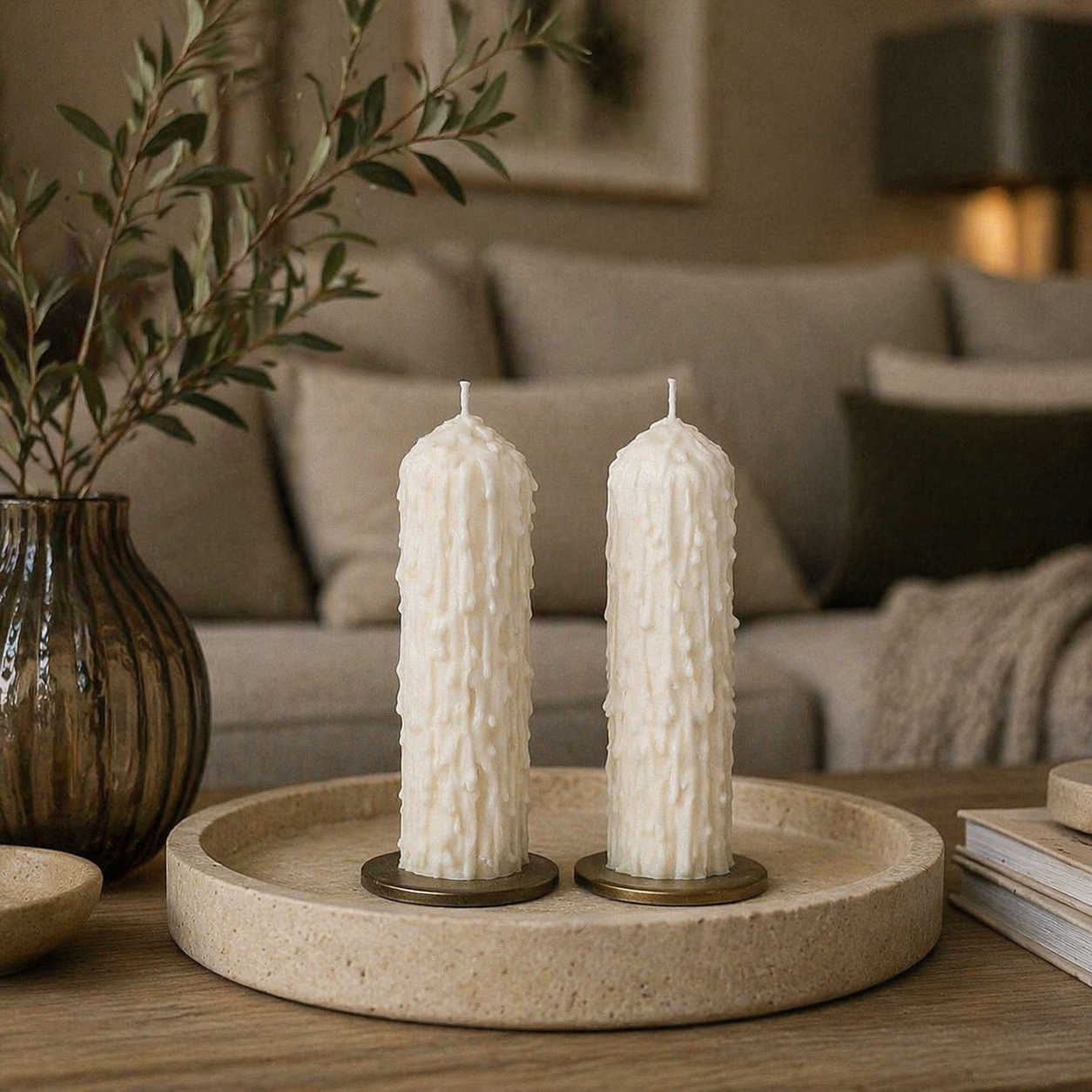 White drip effect soy wax pillar candles styled on a tray with candle holders in a neutral interior