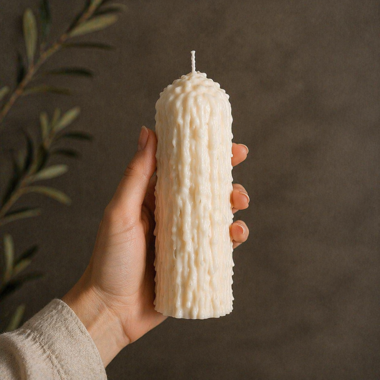 Close up of white drip effect soy wax pillar candle showing handmade pre-dripped texture